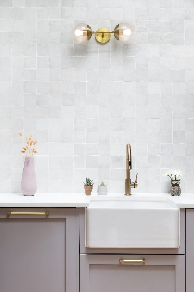 a white sink and purple cabinets