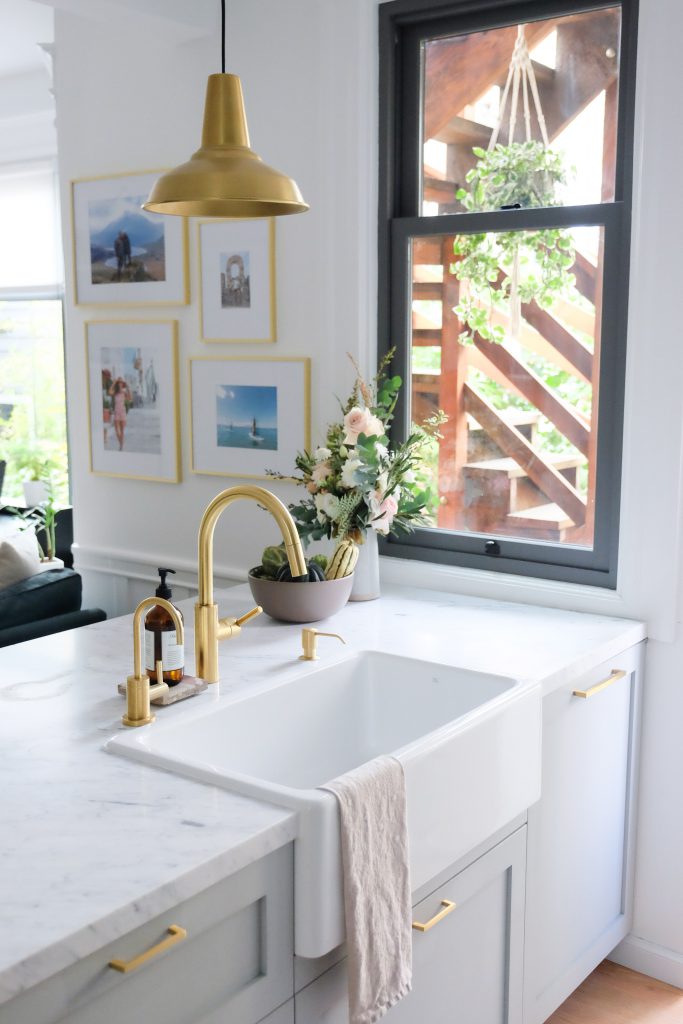 a gold sink faucet matches a good sconce.