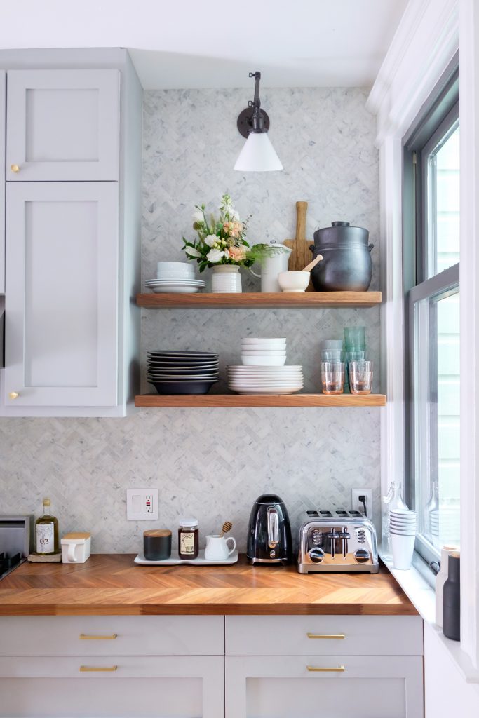 open shelving in the kitchen displays dishes and utensils.