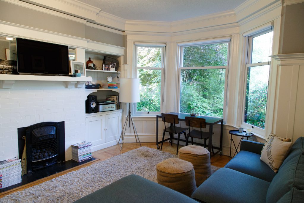 a living room with a desk, couch, and built-in bookcases.