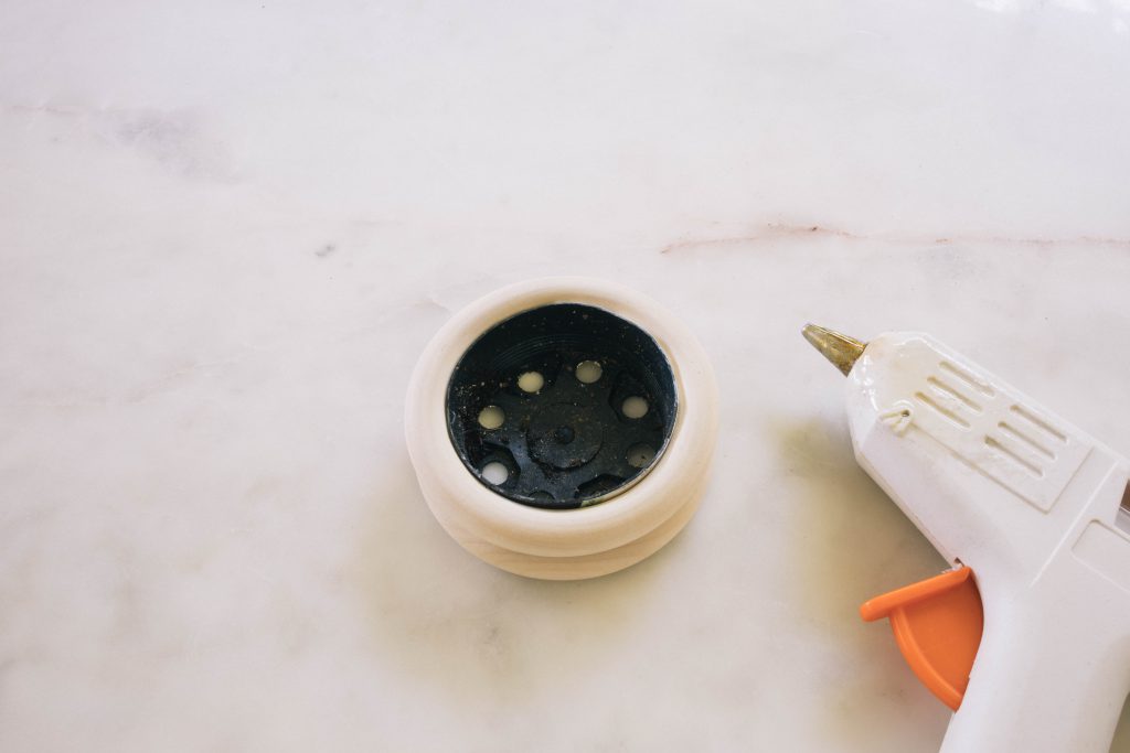 starting to glue rings on to a pot with a glue gun