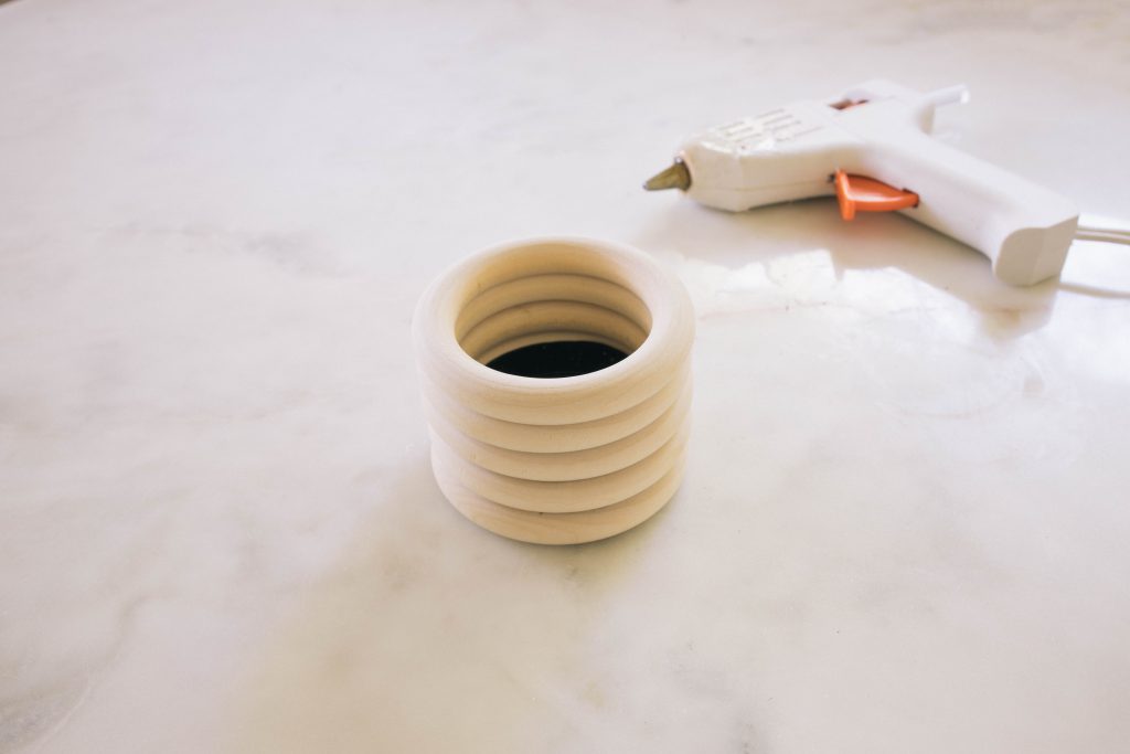 gluing rings on to a pot with a glue gun