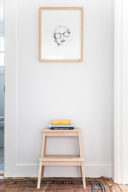 A hallway with a stool and books