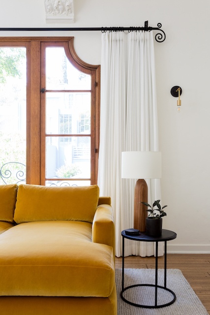 a close up of the yellow couch and side table