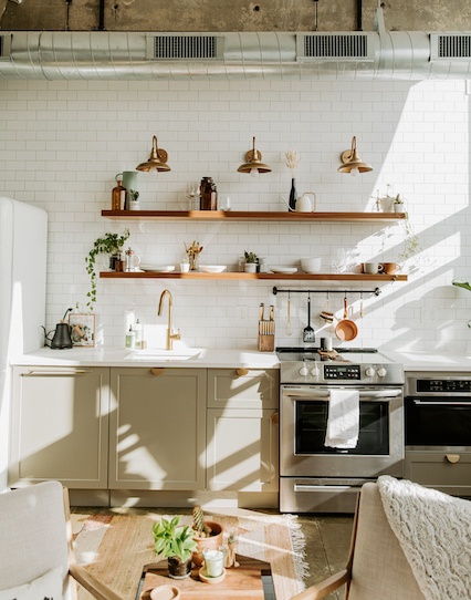 the renovated kitchen has open shelving and gray cabinets.