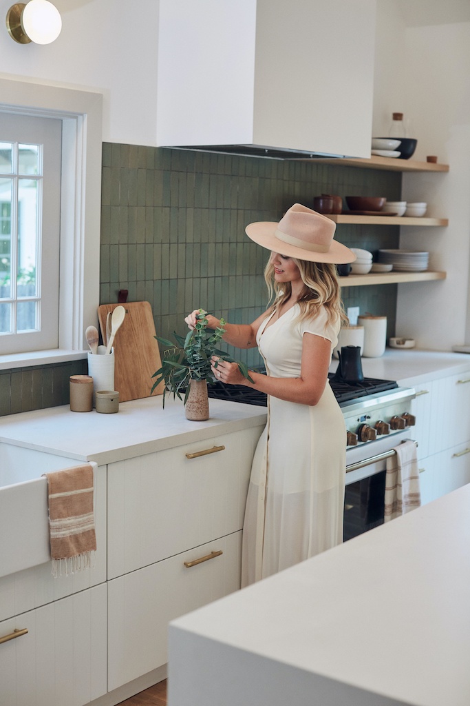 Carly arranges greenery in a vase.
