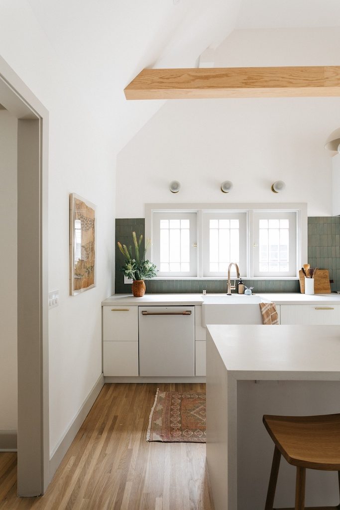 a bright kitchen with a green tile backsplash