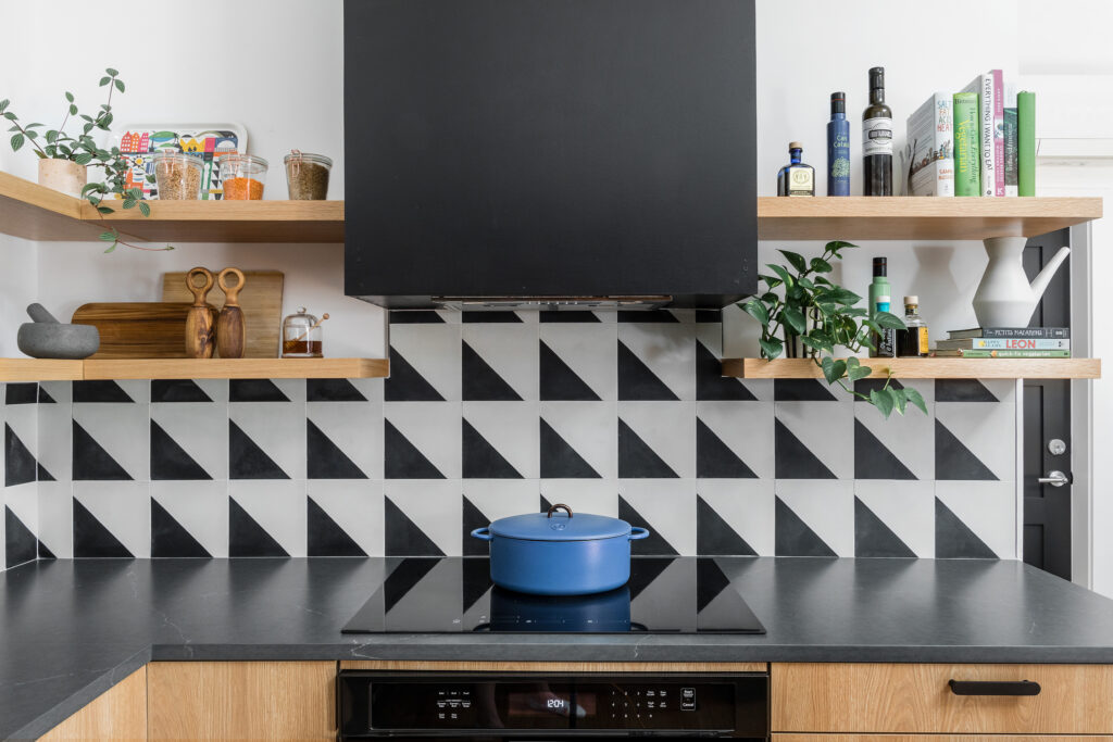 straight-on shot of the oven, hood, and open shelving. a blue Dutch oven sits on the range.