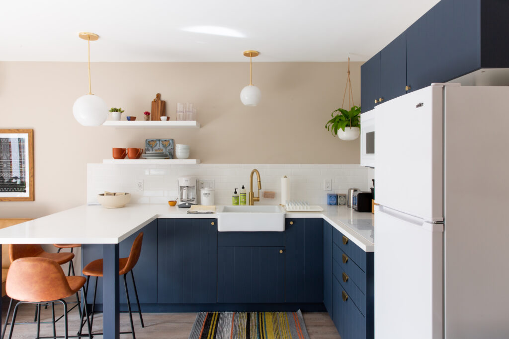 White floating shelves in navy kitchen