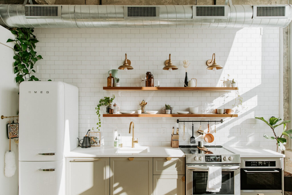 Walnut floating shelves in sage green kitchen