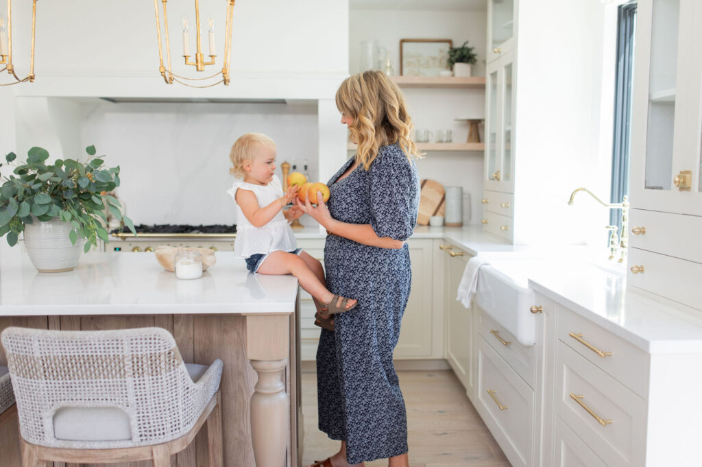 Woman playing with her child in a white renovated kitchen