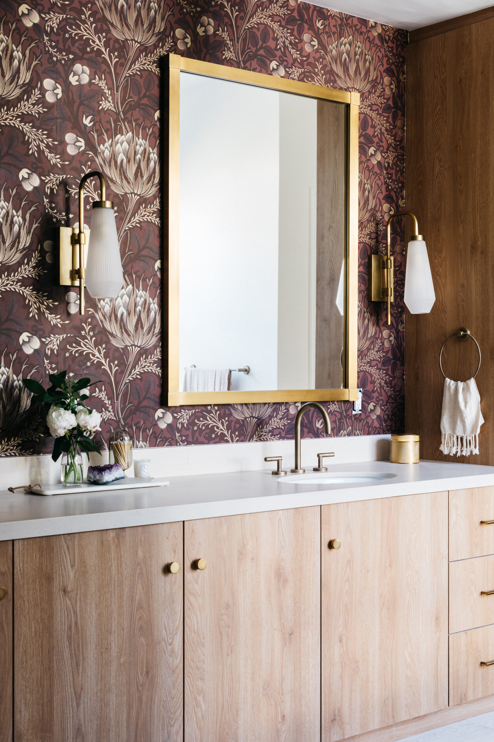Wood bathroom vanity with mauve wallpaper