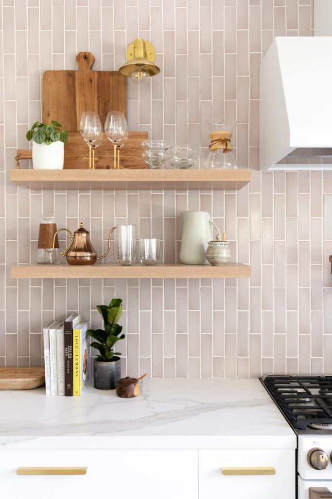 Open shelving against pink tile backsplash