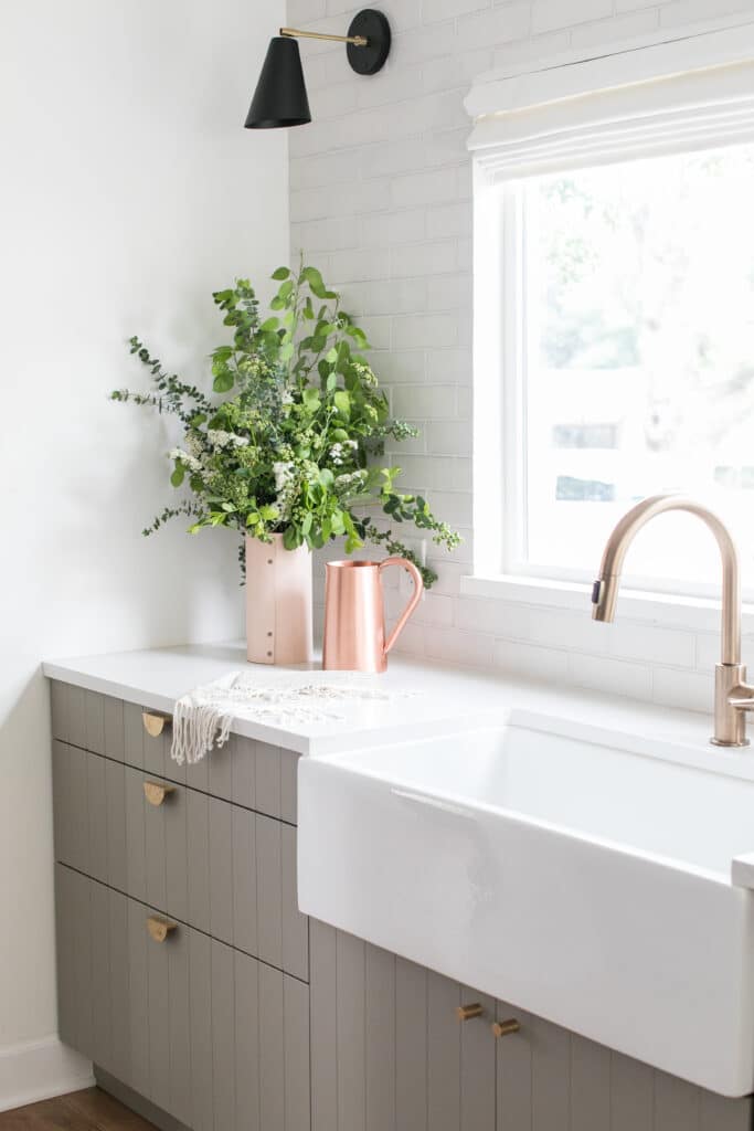 Gray kitchen cabinets with white farmhouse sink