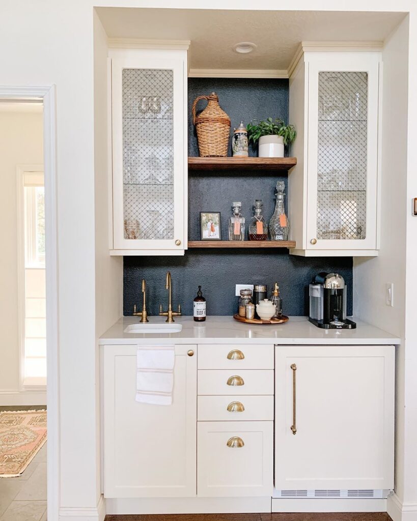 Home bar with off white cabinets and a slate gray backsplash