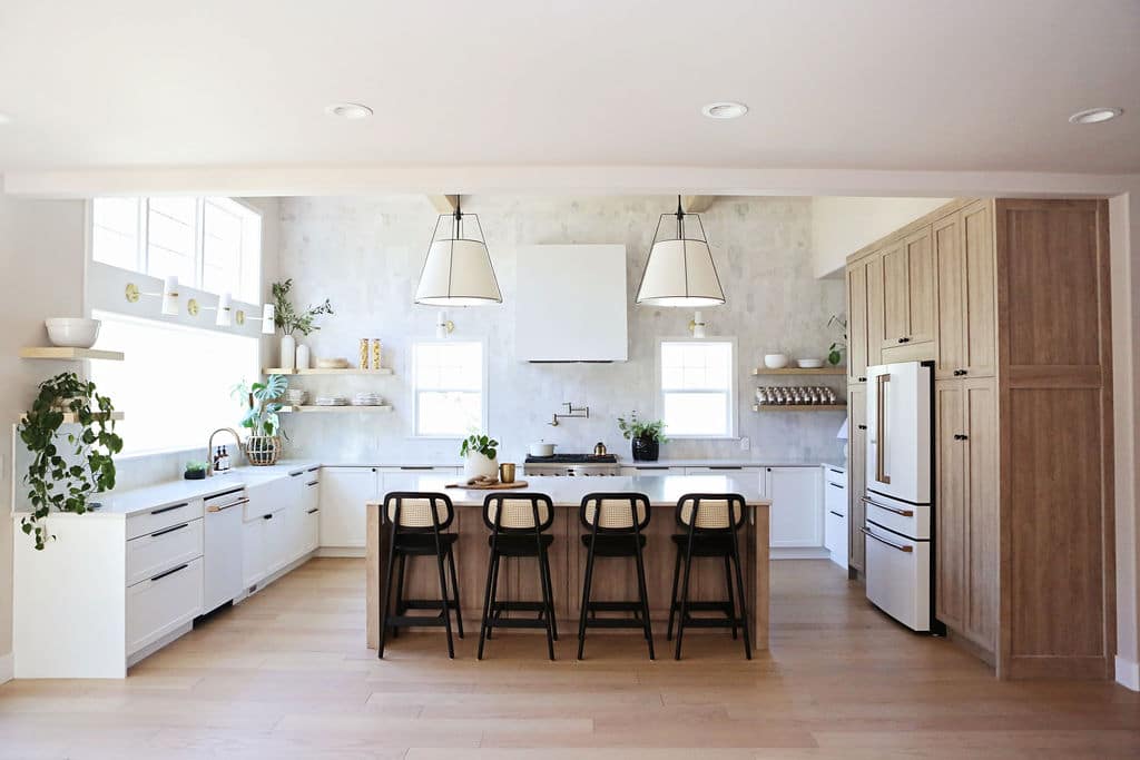 White and wood kitchen with an expansive island and pendants