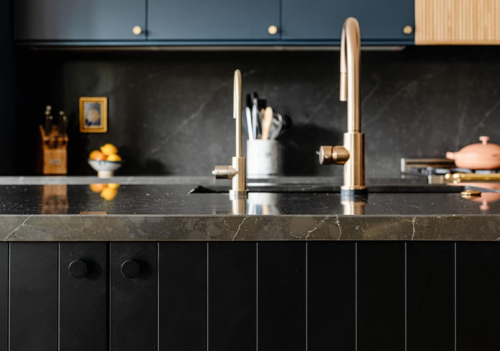 Black beaded island with navy kitchen cabinets