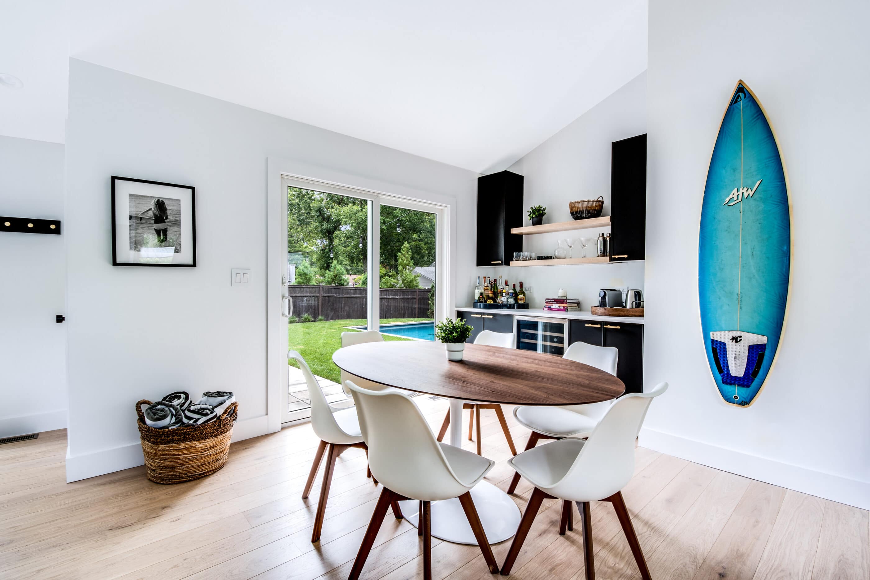 Bar with a turquoise surfboard hanging in the dining room