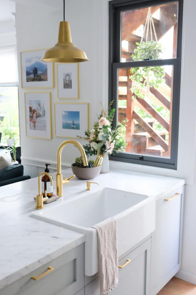 Gray kitchen cabinets with a white farmhouse sink